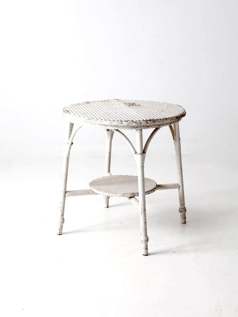 Vintage Early 20th Century White Wicker Accent Table: Vintage Early 20th Century White Wicker Accent Table This early 20th century antique wicker accent table exudes charm with its classic design. It features a round tabletop, supported by elegantly spla