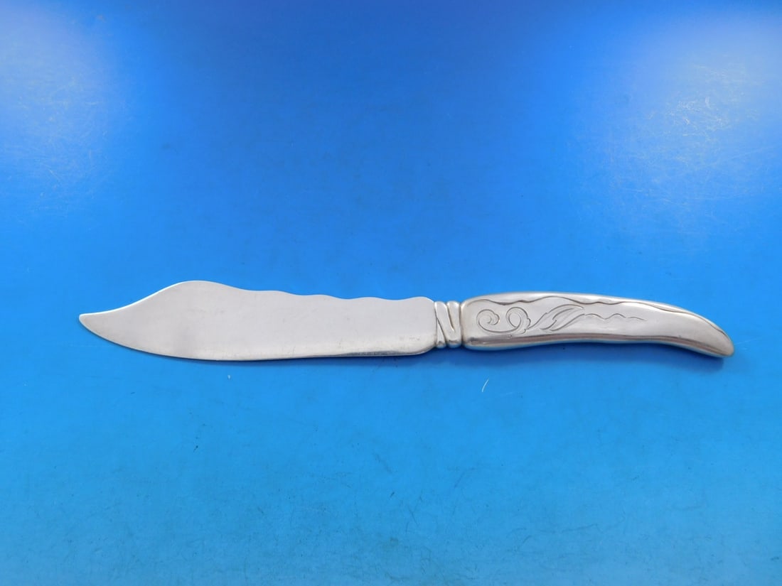 Tiffany & Co. Lap Over Edge Sterling Silver Fish Knife 7 7/8" Wave Motif: Tiffany & Co. Lap Over Edge Sterling Silver Fish Knife 7 7/8" Wave Motif This exquisite fish knife, crafted by Tiffany & Co., features a stunning Lap Over Edge design with an elegant wave motif. Made 