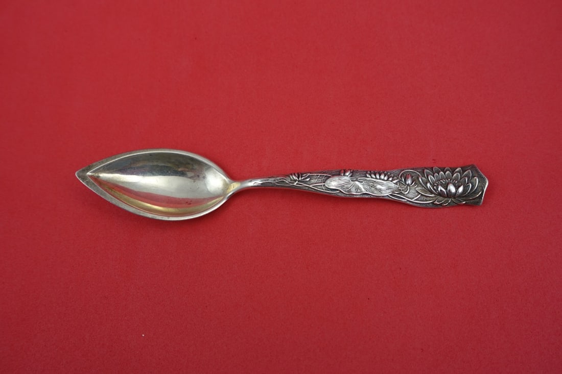 Sterling Silver Grapefruit Spoon Flora Pattern Pond Lily Motif 5 3/4 Inch: Sterling Silver Grapefruit Spoon Flora Pattern Pond Lily Motif 5 3/4 Inch This is a sterling silver grapefruit spoon crafted by Shiebler in the Flora pattern, featuring a decorative pond lily design. 