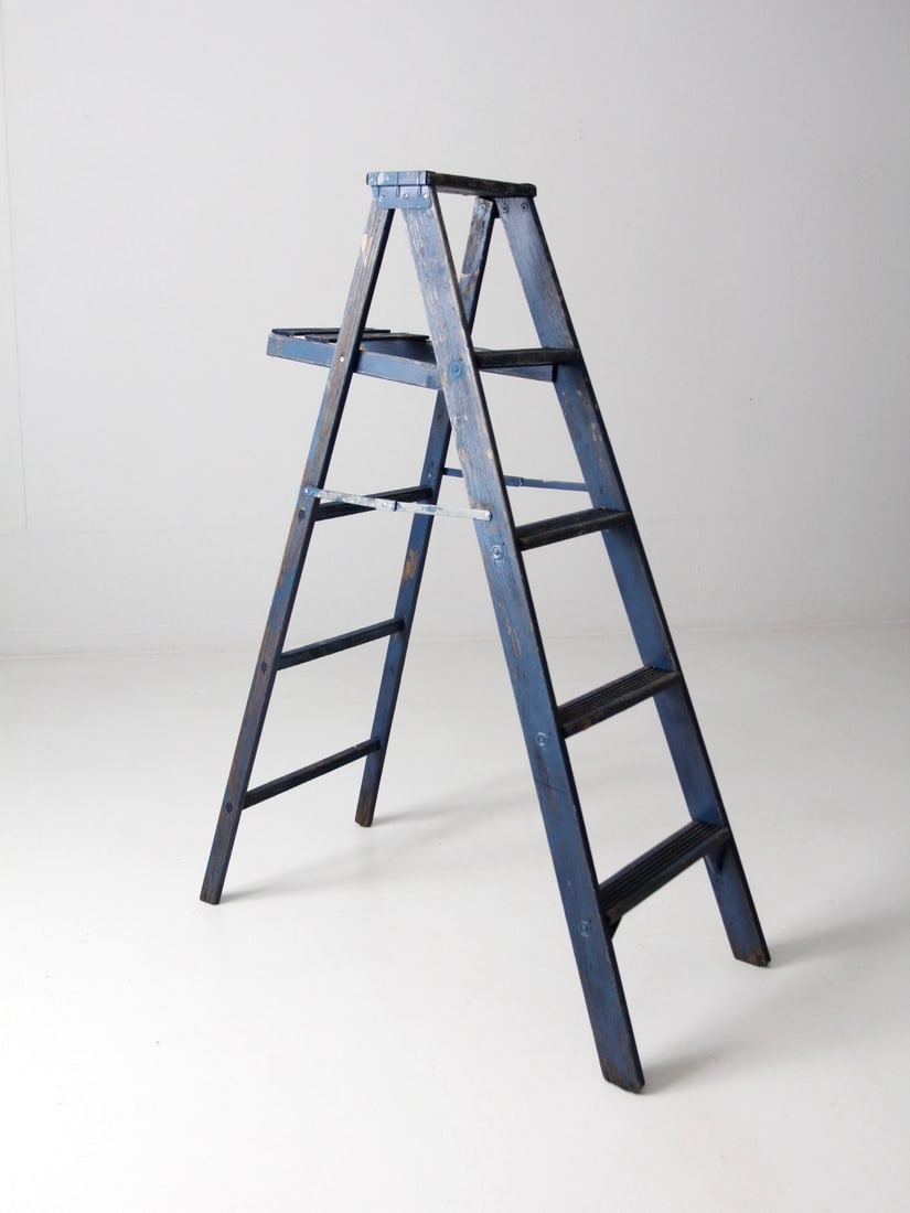 Vintage A-frame blue wood painter ladder 4 rungs: Vintage A-frame blue wood painter ladder 4 rungs This vintage wooden ladder features a classic a-frame design with four rungs and a distinctive aged blue finish, adding character and charm to any spac
