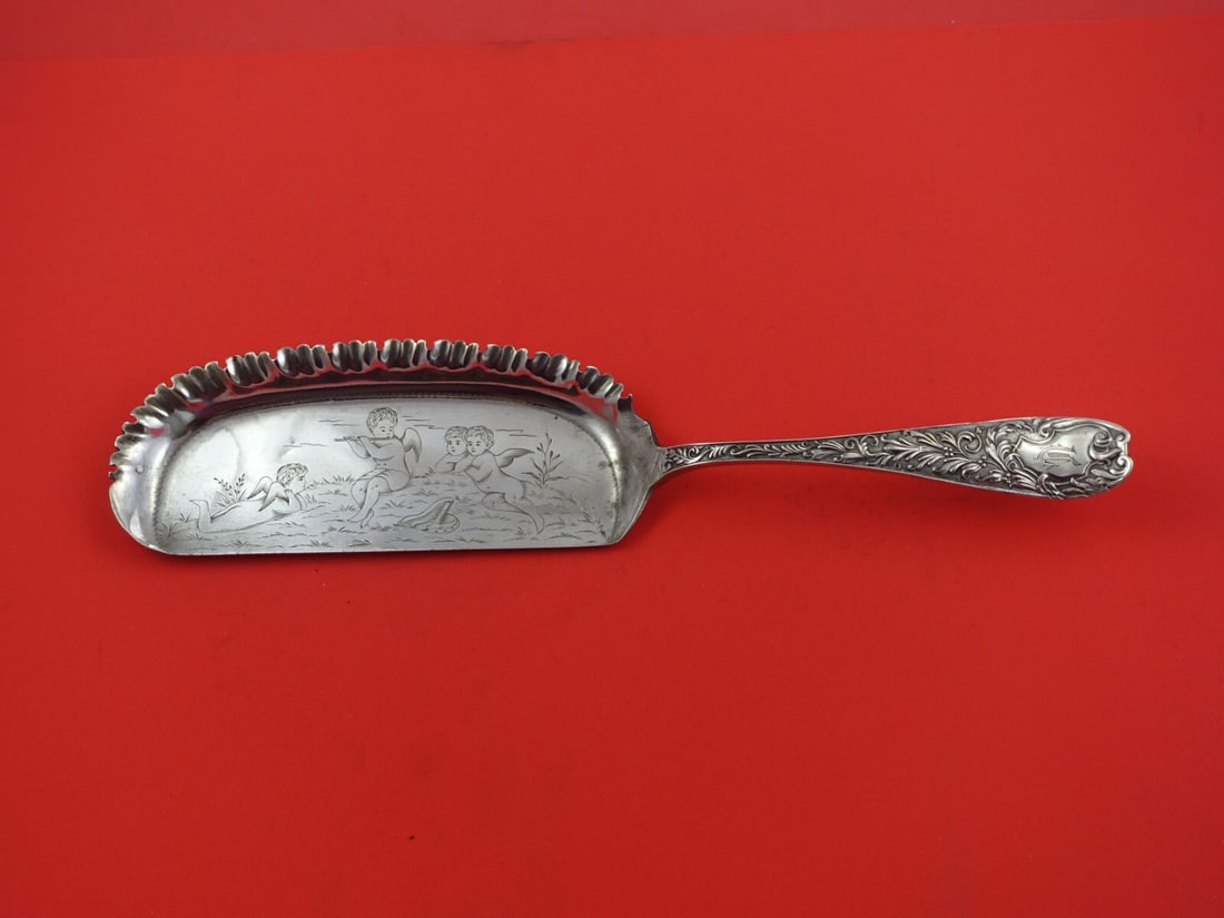 Knowles Sterling Silver Aeolian Crumber with Cherubs 11 3/4": Knowles Sterling Silver Aeolian Crumber with Cherubs 11 3/4" This exquisite sterling silver crumber is part of the Aeolian pattern by Knowles, crafted between 1850 and 1899. It features five beautiful