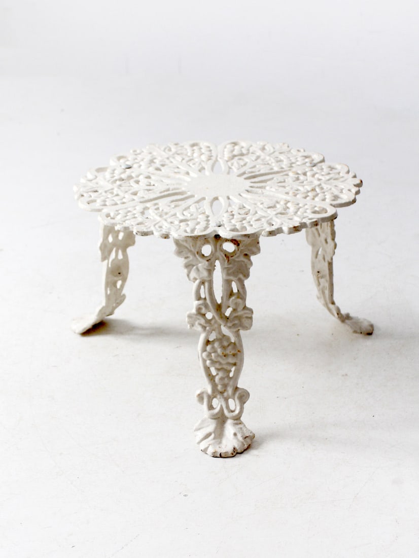 Antique White Cast Iron Garden Table with Grape Leaf Design: Antique White Cast Iron Garden Table with Grape Leaf Design Enhance your living space with this Antique White Cast Iron Garden Side Table, showcasing a beautifully detailed grape leaf design and a cha