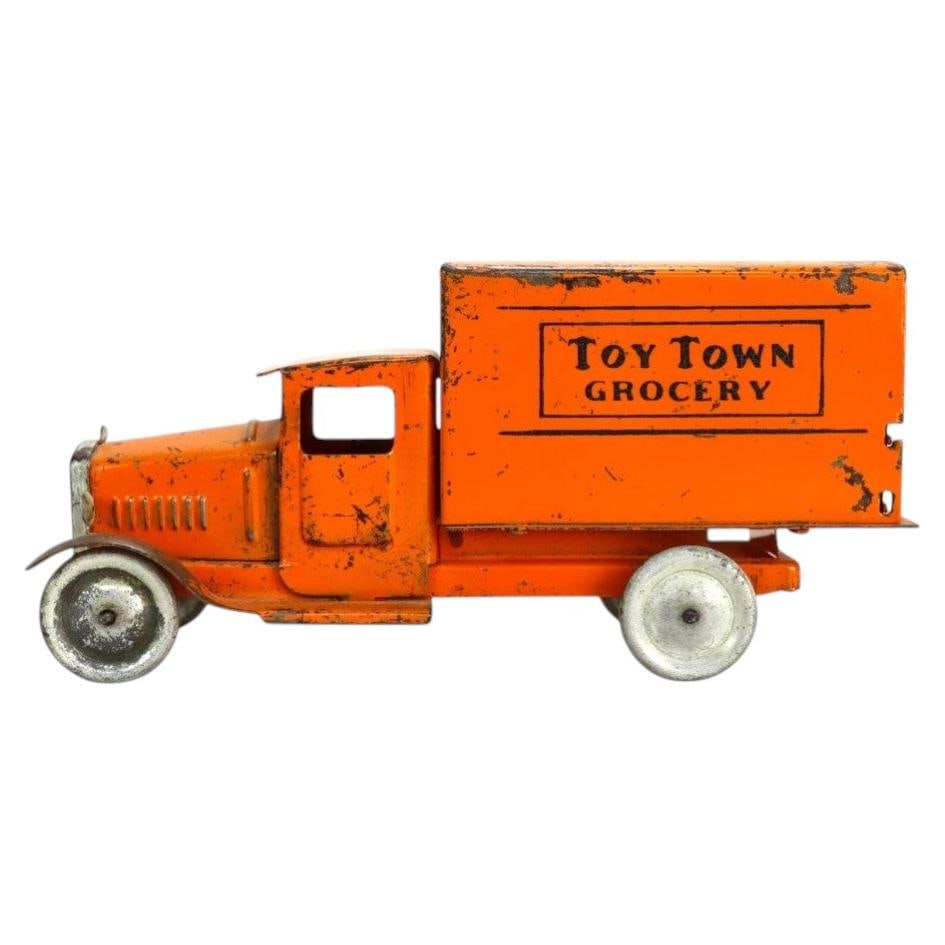 c1920 Pressed Steel Toy Truck Toy Town Grocery Advertising: c1920 Pressed Steel Toy Truck Toy Town Grocery Advertising An antique pressed steel advertising truck dating to approximately 1920. This toy vehicle features an orange painted finish with black letter