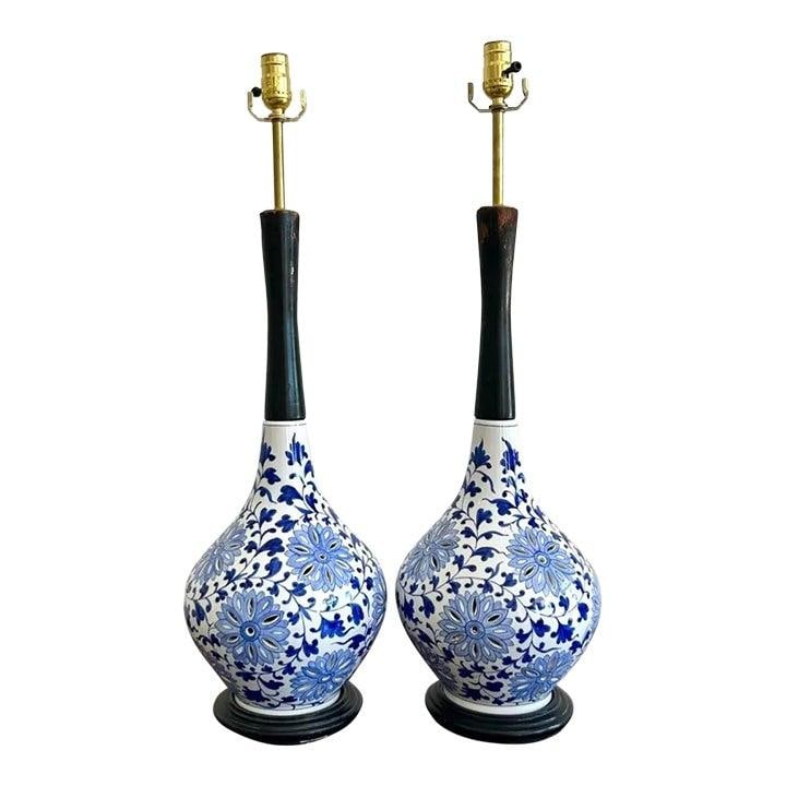 Pair of Blue Floral Ceramic Table Lamps with Wood and Brass Accents: Pair of Blue Floral Ceramic Table Lamps with Wood and Brass Accents This pair of vintage boho table lamps features bulbous ceramic bases with intricate blue floral motifs on a white background, inspir