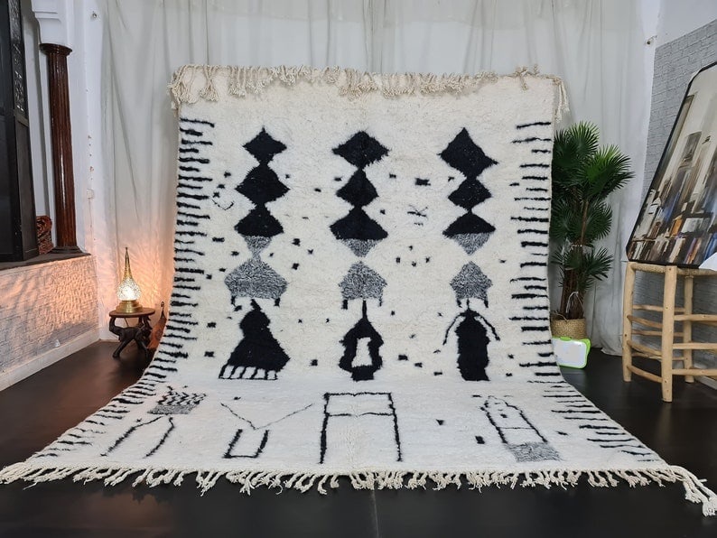 Handmade Moroccan Berber Wool Rug Soft White with Black Pattern: Handmade Moroccan Berber Wool Rug Soft White with Black Pattern Experience the elegance of this Soft White Handmade Moroccan Berber Wool Rug featuring a striking black pattern and lines. Handwoven in 