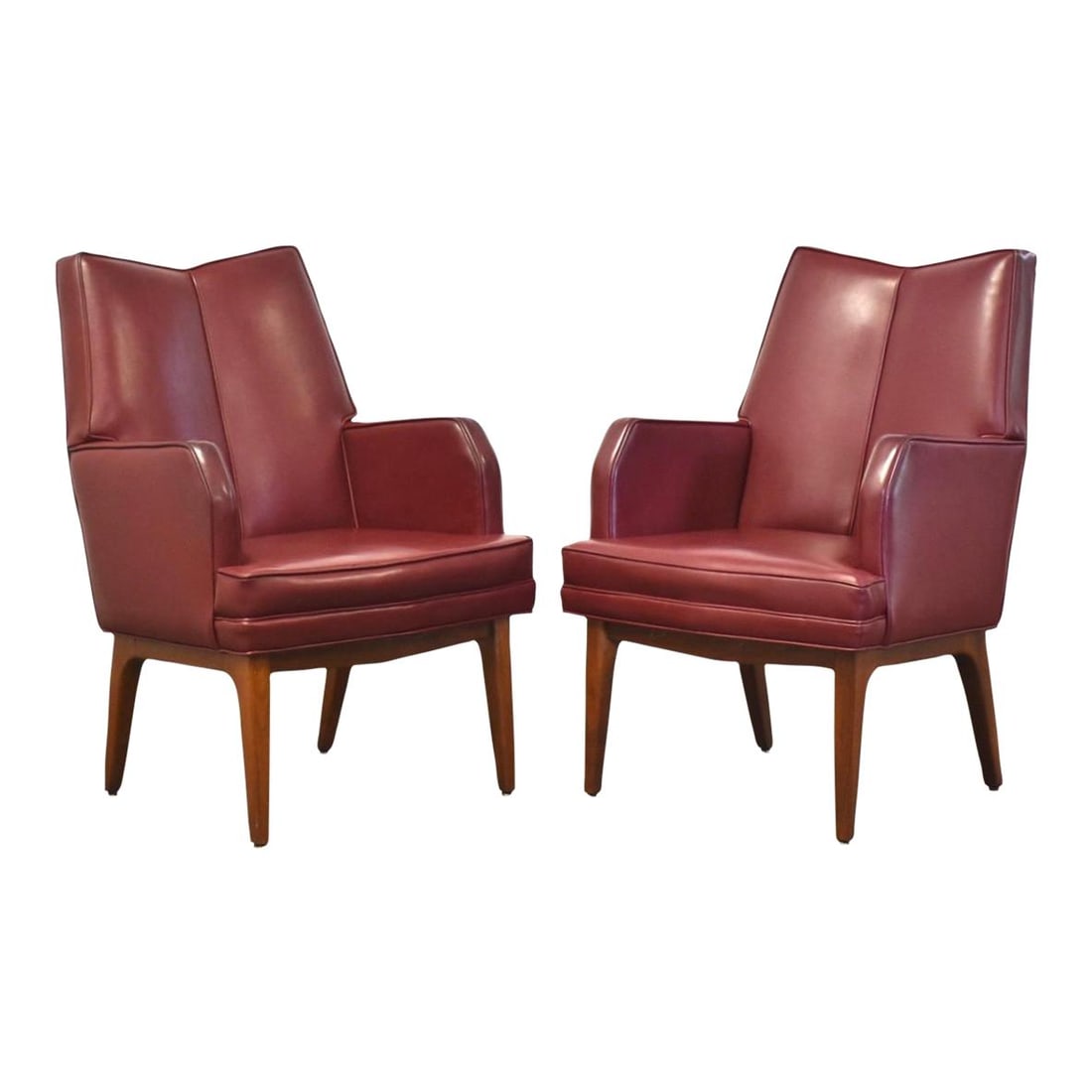 Mid-Century Modern Maroon Lounge Chairs with Walnut Legs - Pair: Mid-Century Modern Maroon Lounge Chairs with Walnut Legs - Pair This stylish pair of mid-century modern lounge chairs features a rich maroon upholstery complemented by sturdy walnut legs. Designed for