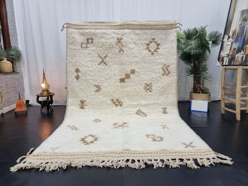 Authentic Handwoven Soft White Wool Rug from Morocco: Authentic Handwoven Soft White Wool Rug from Morocco Experience the charm of an authentic handmade soft white rug, intricately designed with various symbols and signs in brown throughout. This exquisi