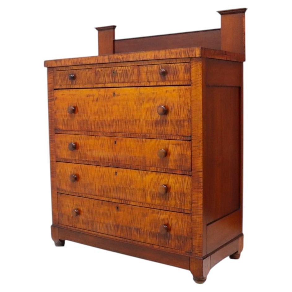 Circa 1830 American Empire cherry high chest with backsplash: Circa 1830 American Empire cherry high chest with backsplash This antique American Empire high chest, crafted circa 1830, features a striking combination of cherry and tiger maple woods. The frame and