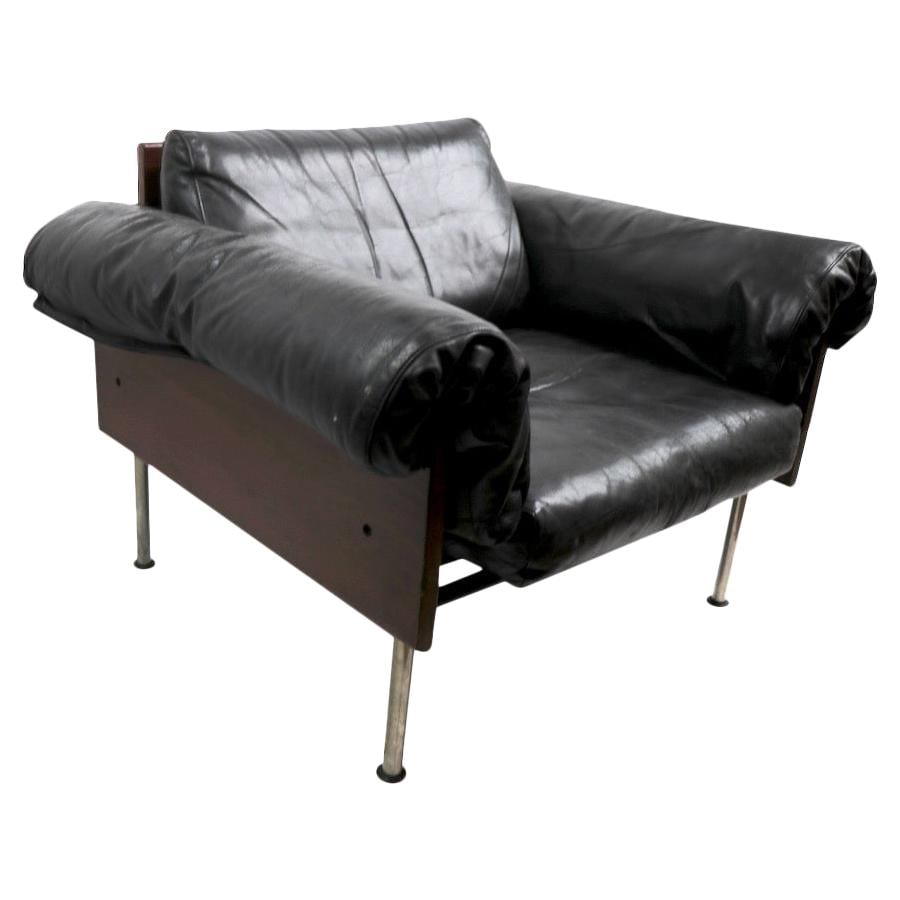 Chic Modernist Rosewood Leather Lounge Chair 1960s-1970s: Chic Modernist Rosewood Leather Lounge Chair 1960s-1970s This Modernist Rosewood and Leather Lounge Chair features a stylish and chic low profile, with solid rosewood sides and back supporting luxurio