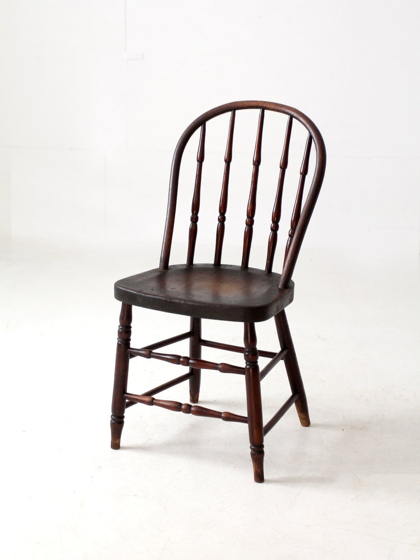 Antique Windsor Chair with Turned Spindles and Warm Finish: Antique Windsor Chair with Turned Spindles and Warm Finish Discover the charm of this antique Windsor-style chair, showcasing a gracefully arched back adorned with finely turned spindles. The shaped s