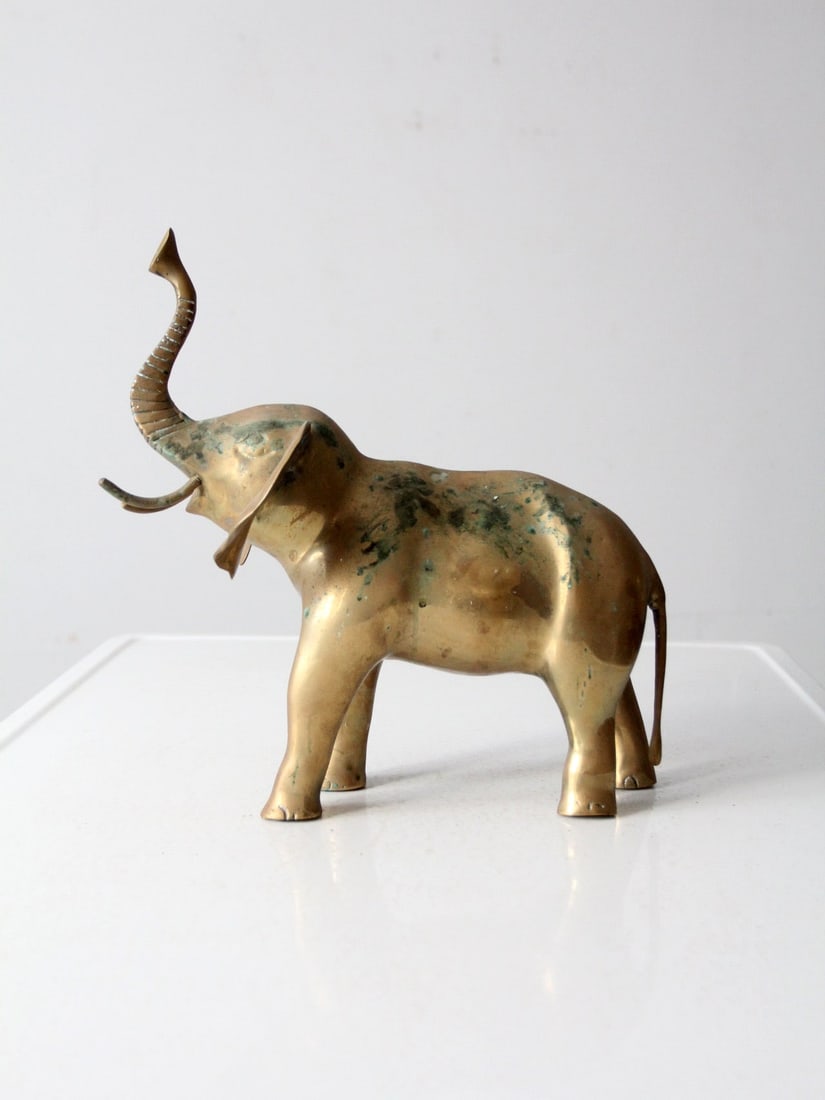 Vintage Brass Elephant 13.25 inch Timeless Decor Piece: Vintage Brass Elephant 13.25 inch Timeless Decor Piece Enhance your decor with this vintage brass elephant, exuding worldly charm and character. The piece features a well-loved patina, showcasing its 