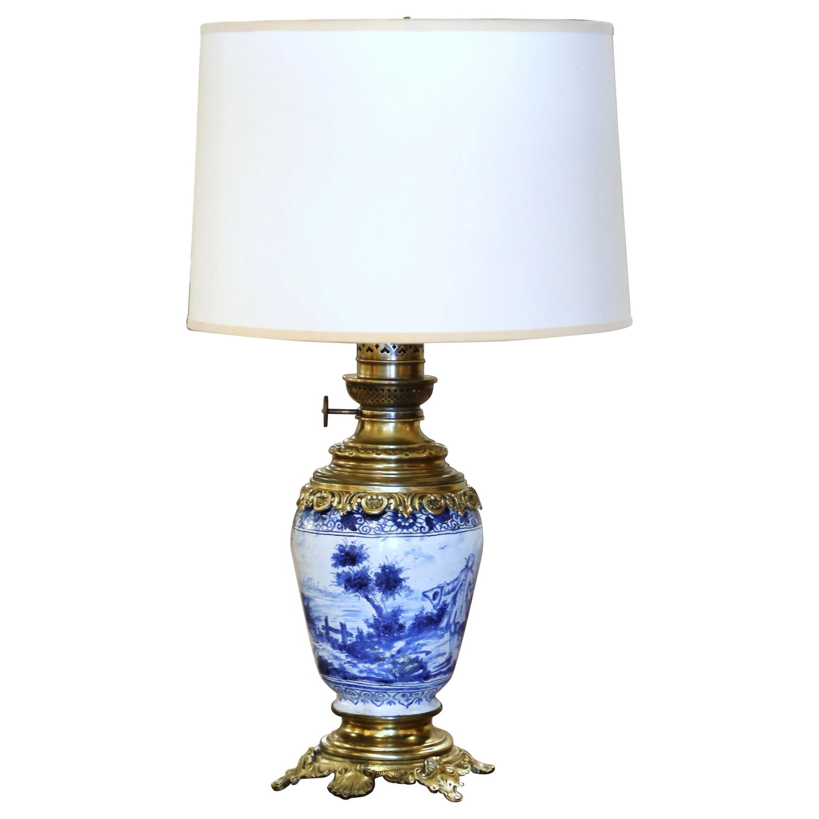 Napoleon III French Porcelain Oil Lamp with Brass Mounts: Napoleon III French Porcelain Oil Lamp with Brass Mounts This late 19th-century French oil lamp, attributed to Delft, features a hand-painted faience ceramic body in classic blue and white tones. The 