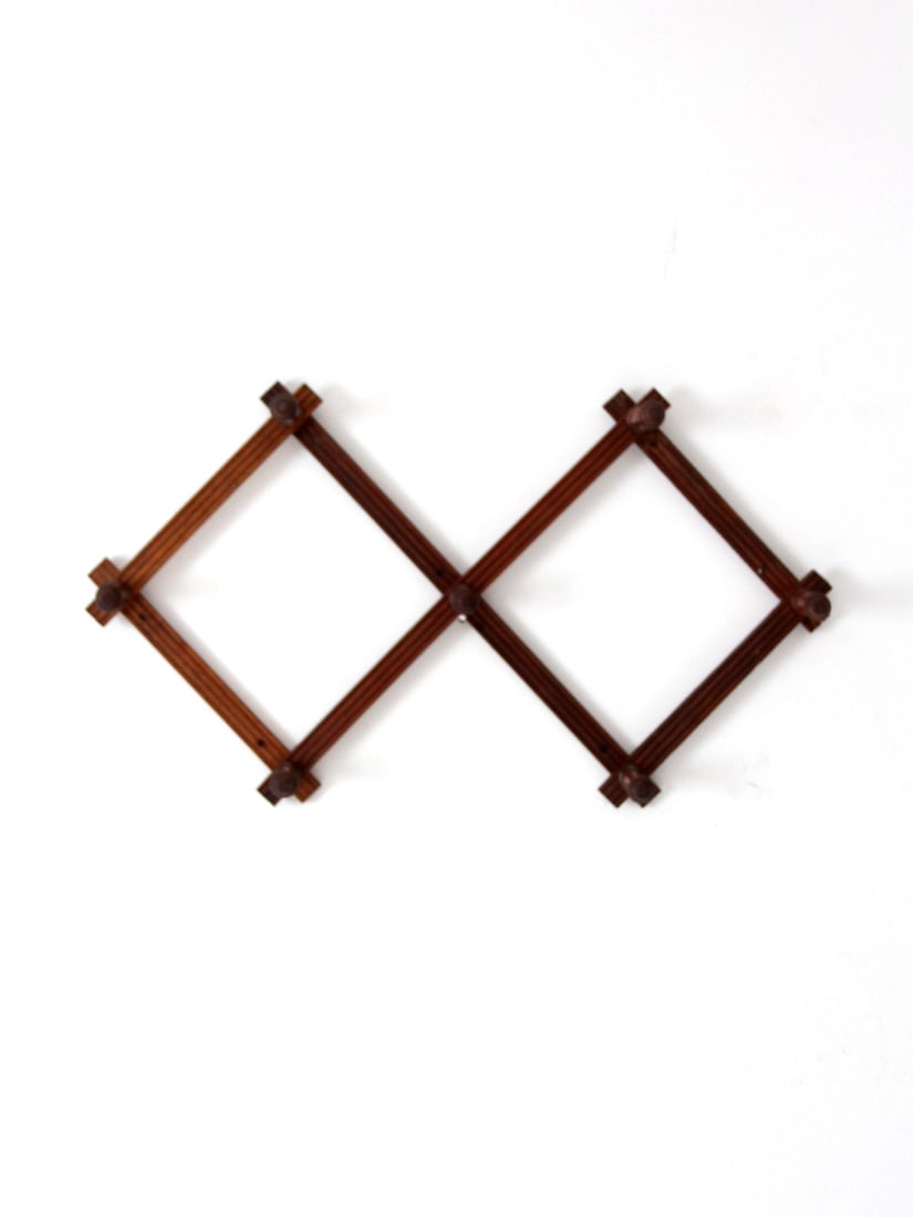 Expandable Wooden Wall Peg Rack with Turned Hooks: Expandable Wooden Wall Peg Rack with Turned Hooks Vintage wooden accordion wall rack with turned pegs and an expanding lattice design that adjusts to fit a variety of spaces. It features a warm staine