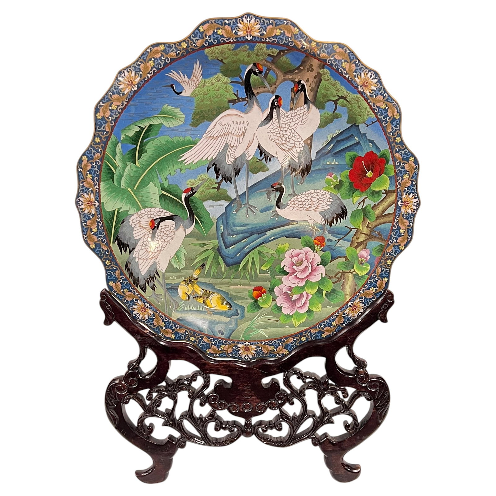 Japanese Cloisonne Charger with Stained Wood Stand: Japanese Cloisonne Charger with Stained Wood Stand This large cloisonne charger features intricate enamel work depicting red-crowned cranes amidst vibrant foliage and flowers. Crafted in the mid-20th 