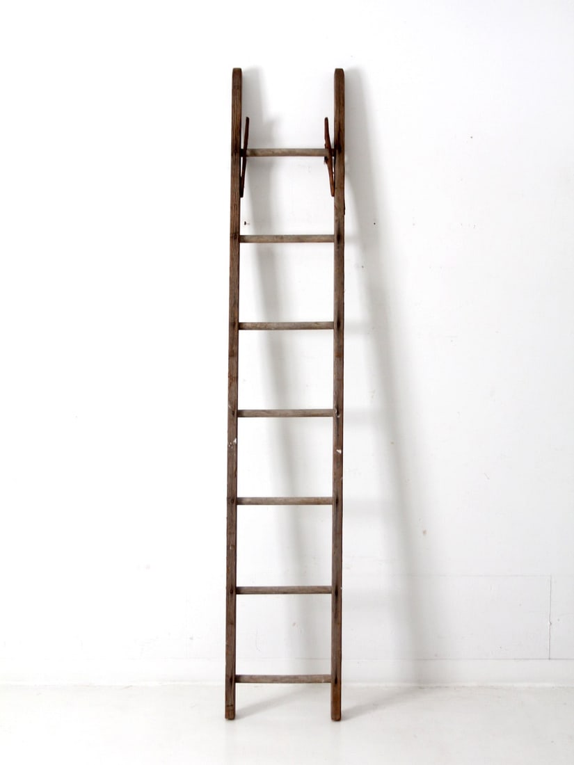 Rustic Wooden Ladder with Seven Rungs and Metal Hardware: Rustic Wooden Ladder with Seven Rungs and Metal Hardware This antique wooden picking ladder features seven rungs and metal hardware, showcasing a rustic charm ideal for decorative purposes such as a b