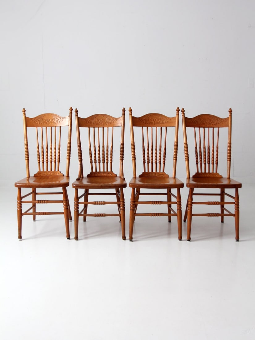 Set of 4 Antique Pressed Back Dining Chairs with Saddle Seats: Set of 4 Antique Pressed Back Dining Chairs with Saddle Seats This set of four antique dining chairs features beautifully pressed backs with decorative turned spindles. The solid wood "saddle" seats p