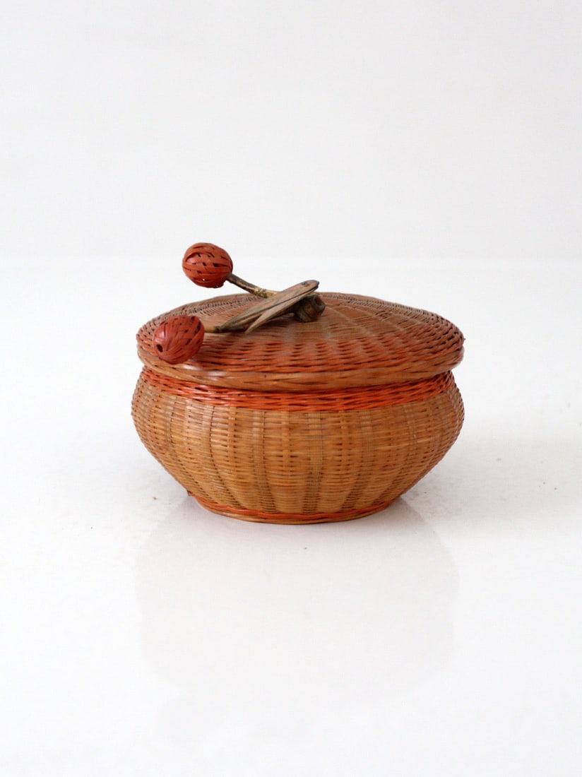 Chinese Mid-Century Woven Basket With Lid and Decorative Berry Finial: Chinese Mid-Century Woven Basket With Lid and Decorative Berry Finial This mid-century Chinese woven basket features a compact, rounded design with a fitted lid. The basket is adorned with a sculptura