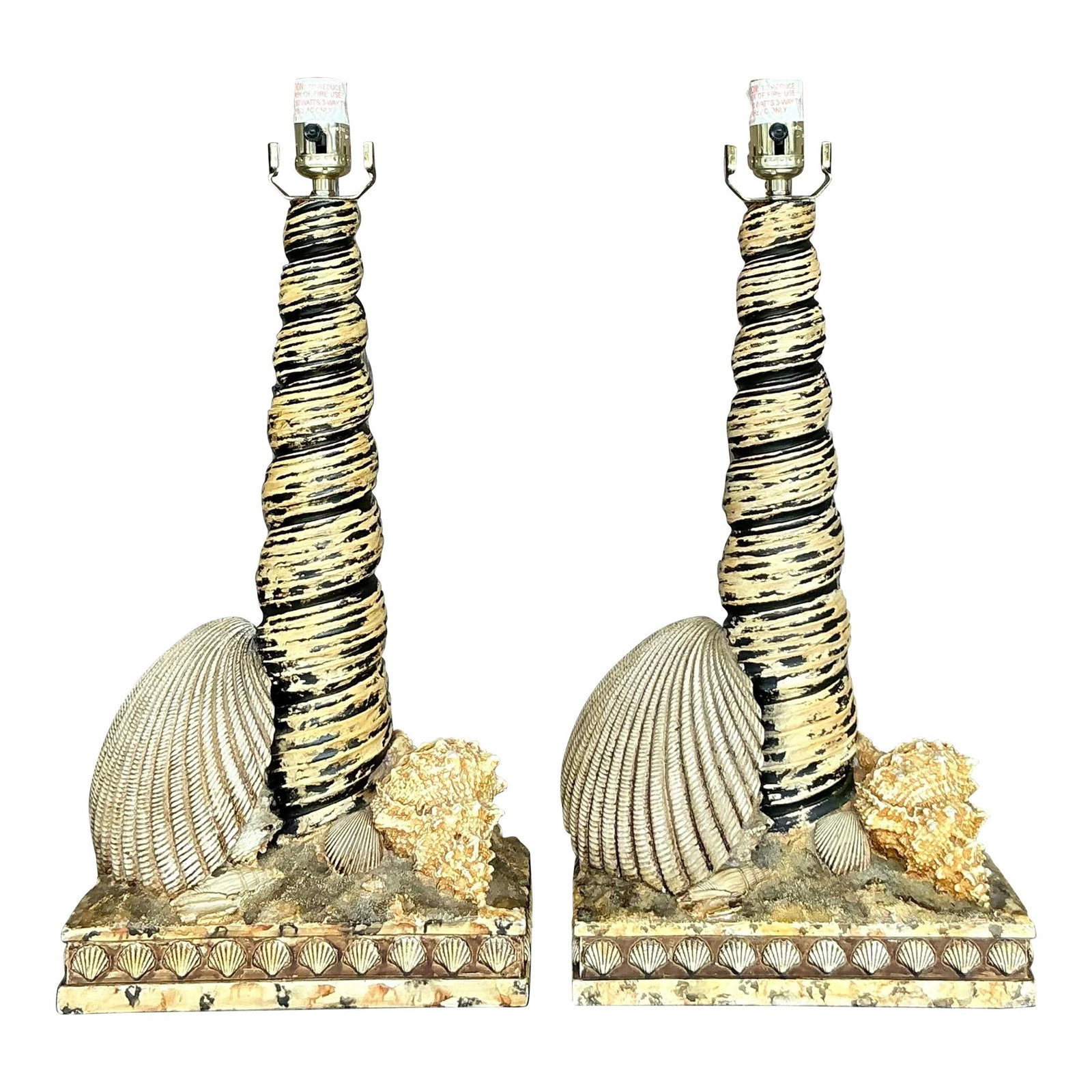 Pair of Vintage Coastal Shell Lamps in Black and Gold: Pair of Vintage Coastal Shell Lamps in Black and Gold Enhance your living space with this exquisite pair of vintage coastal resin shell lamps. Each lamp features a textured resin base adorned with bea
