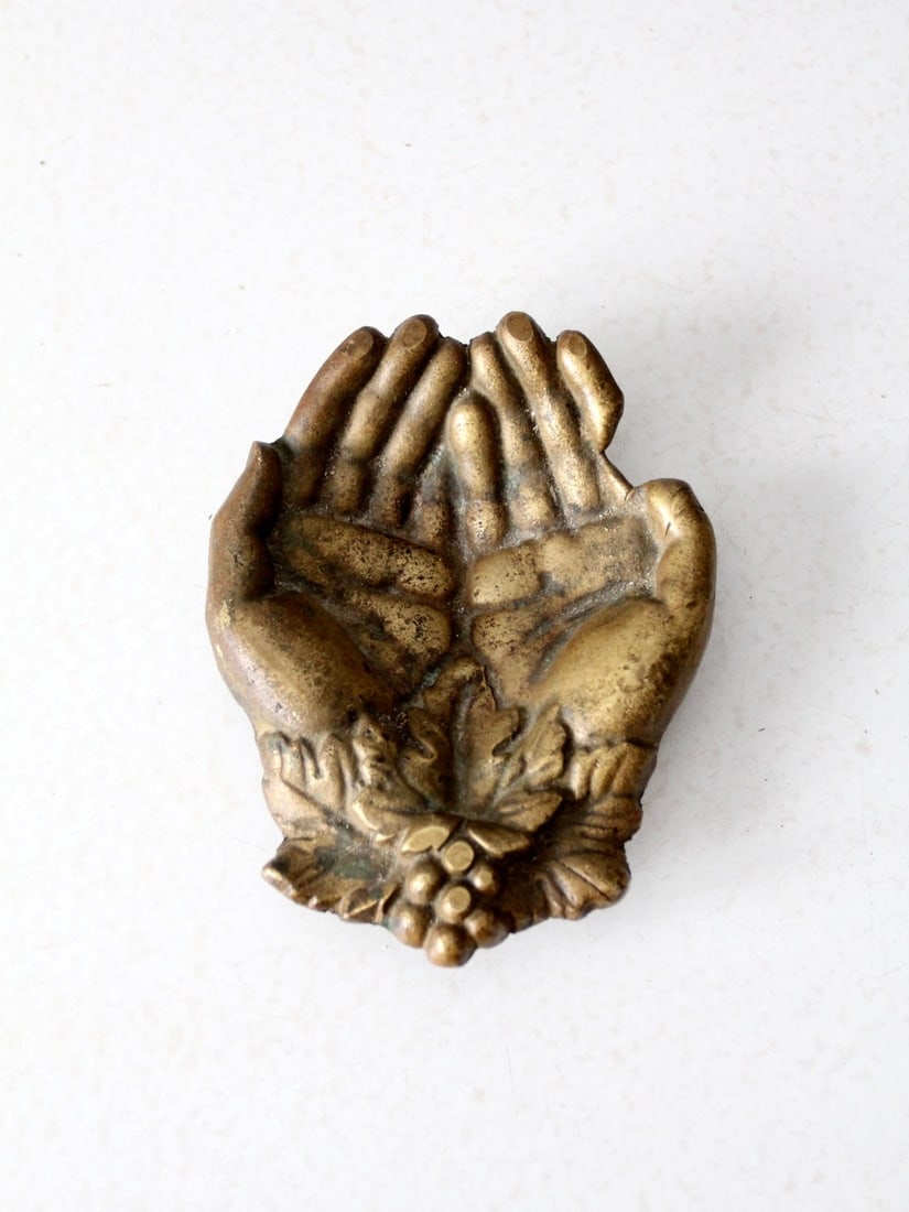 Brass Cupped Hands Decorative Dish with Grape Motif Mid-20th Century: Brass Cupped Hands Decorative Dish with Grape Motif Mid-20th Century This mid-century brass dish features a sculptural design in the shape of cupped hands, adorned with a grape and leaf motif at the w