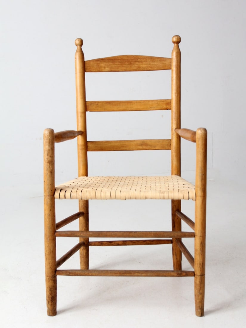 Shaker-Inspired Antique Armchair with Woven Cane Seat: Shaker-Inspired Antique Armchair with Woven Cane Seat This antique armchair features a timeless Shaker-inspired design, highlighted by a woven herringbone cane seat. The sturdy wooden frame is elegant