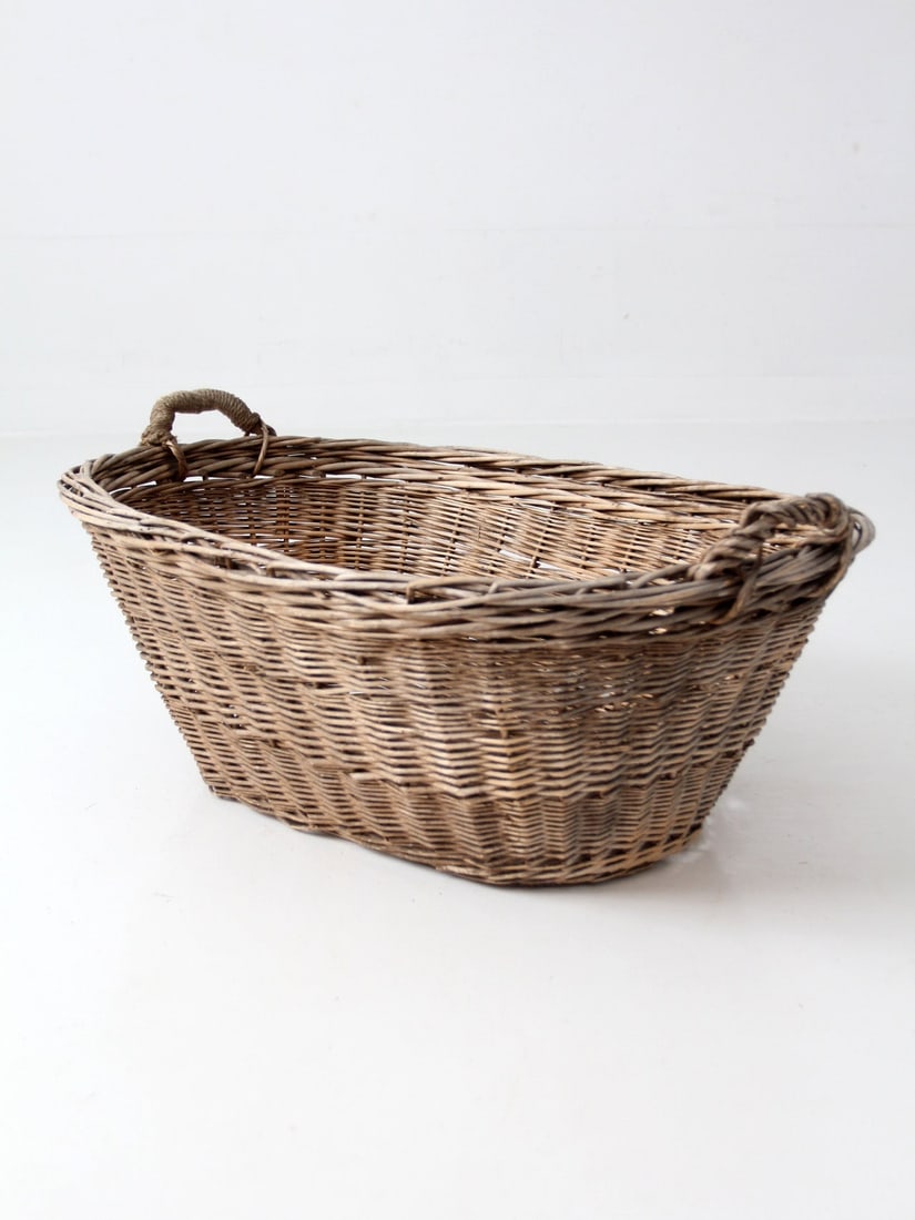 Oval Handwoven Wicker Utility Basket with Wood Base French Country: Oval Handwoven Wicker Utility Basket with Wood Base French Country Antique French country wicker laundry basket with an elongated oval form, thick handwoven construction, wrapped side handles, and a d