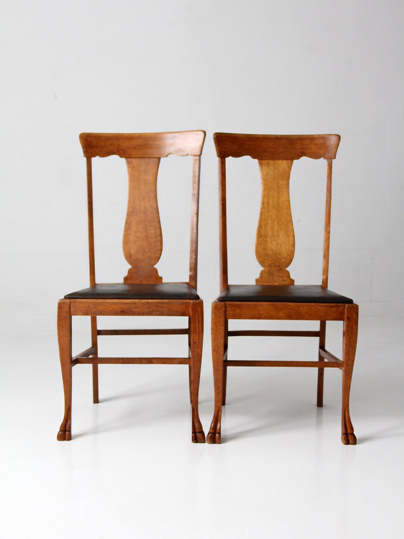 Pair of Oak Splat Back Side Chairs with Claw Feet: Pair of Oak Splat Back Side Chairs with Claw Feet This pair of 1930s oak splat back side chairs features carved claw feet and dark faux leather seats. The chairs have shaped splats and tall, narrow ba