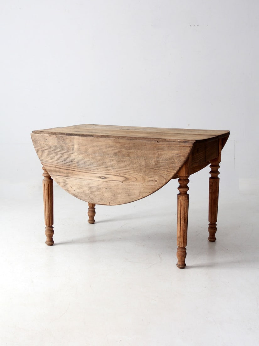 Antique Drop Leaf Table Oval Design Farmhouse Style: Antique Drop Leaf Table Oval Design Farmhouse Style This antique drop-leaf dining table embodies the timeless charm of early farmhouse design. The oval tabletop showcases a softly weathered finish, hi
