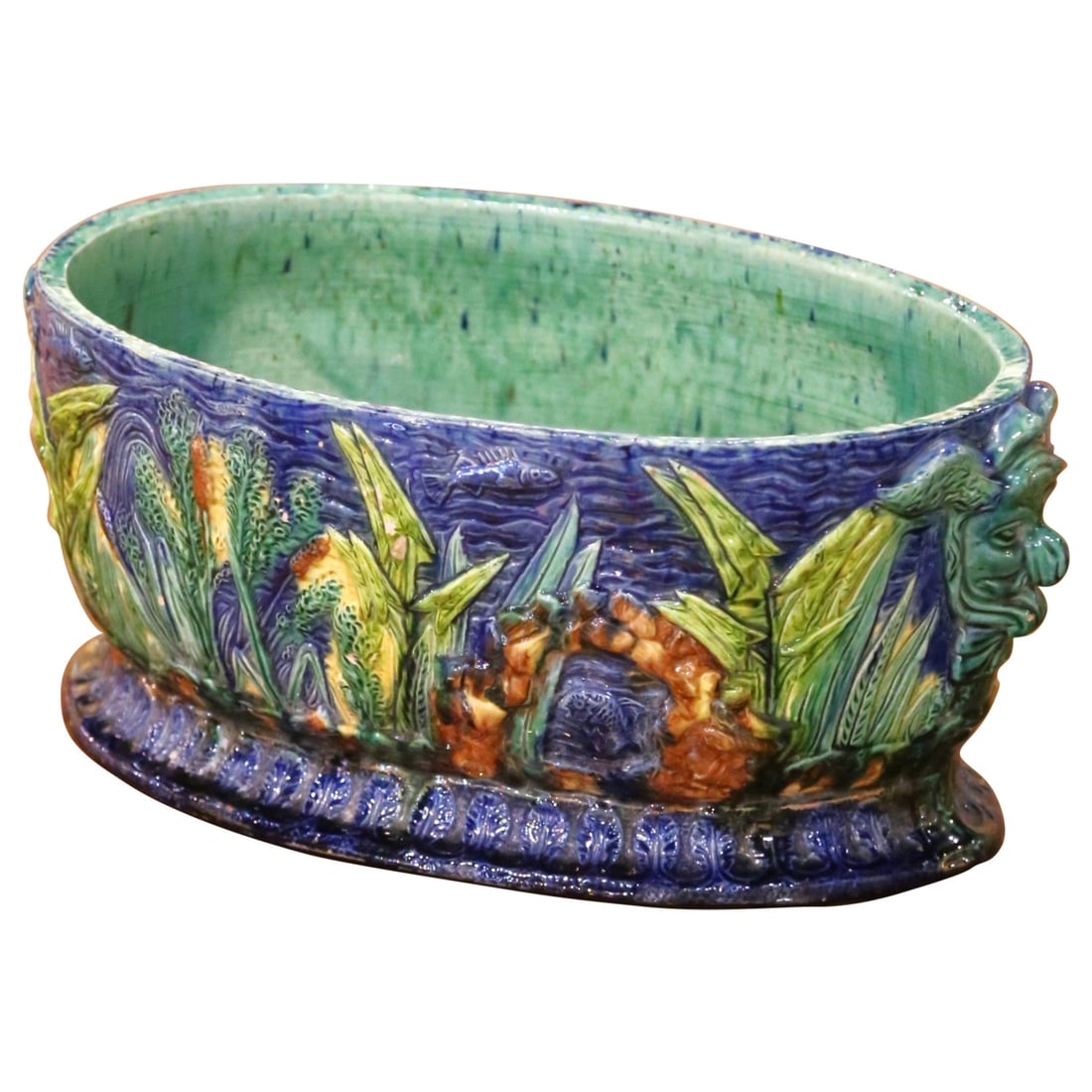 French Majolica Ceramic Cachepot with Sculpted Mask Handles Circa 1880: French Majolica Ceramic Cachepot with Sculpted Mask Handles Circa 1880 This late 19th-century French majolica cache pot is a finely hand-crafted ceramic piece dating to circa 1880. The oval jardiniere