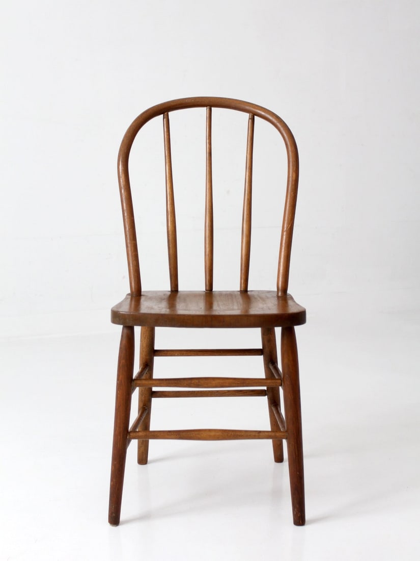 Early American Bow Back Windsor Dining Chair: Early American Bow Back Windsor Dining Chair This vintage Windsor style bow back dining chair features a classic Early American design with a curved spindle back, tapered legs, and warm, aged wood ton