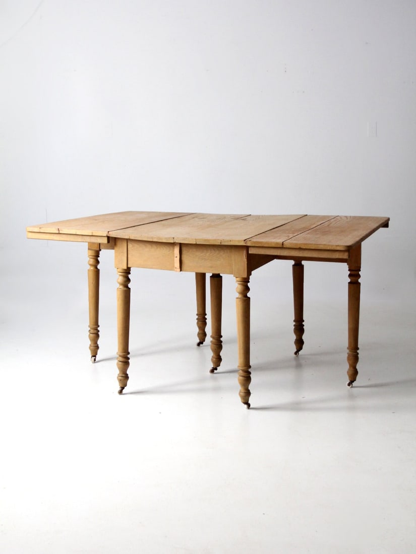 Circa 1890 Antique Gate Leg Table with Drop Leaves and Ceramic Casters: Circa 1890 Antique Gate Leg Table with Drop Leaves and Ceramic Casters This antique gate leg table, dating back to circa 1890, showcases a charming and functional design. Crafted from wood, it feature