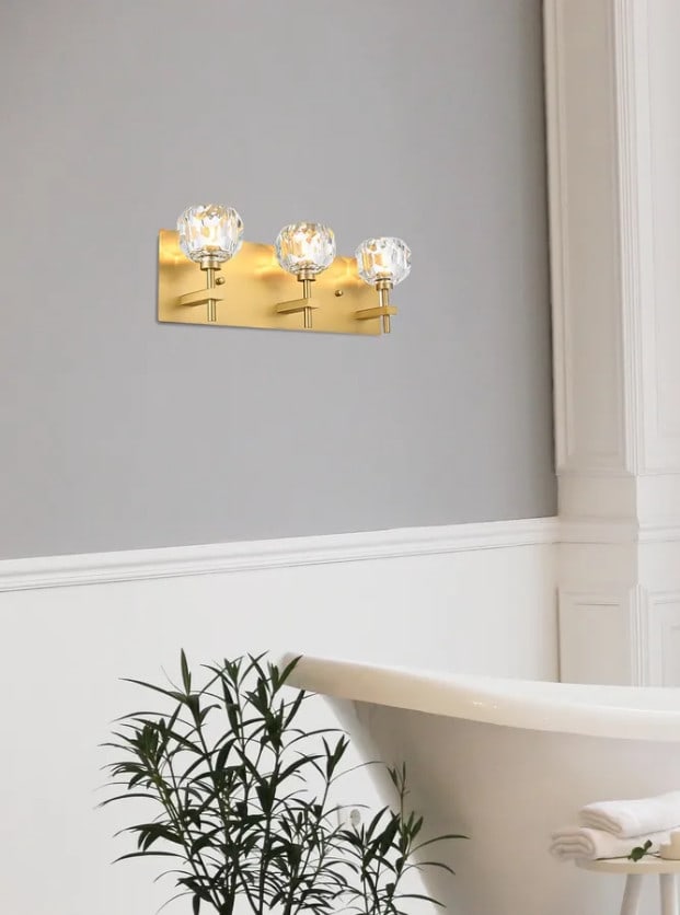Graham 3 Light Gold Crystal Wall Sconce 18 Inch: Graham 3 Light Gold Crystal Wall Sconce 18 Inch This modern wall sconce from the Graham Collection features a gold finish and clear crystal shades, providing a sophisticated lighting solution for indo