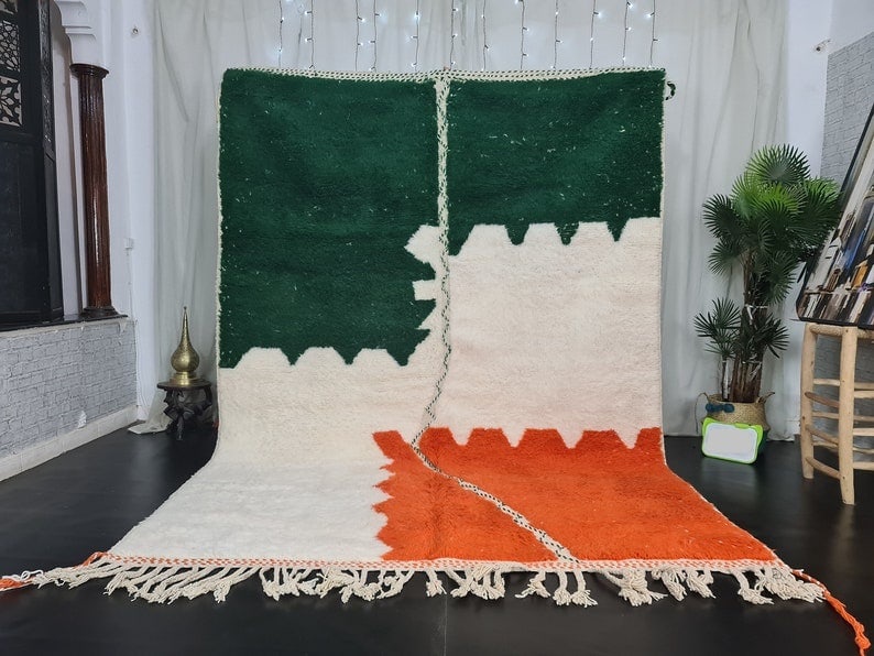 Handmade Moroccan Berber Wool Rug 9.84 x 6.56 Feet: Handmade Moroccan Berber Wool Rug 9.84 x 6.56 Feet Experience the charm of this Authentic Soft Handmade Moroccan Berber Wool Rug, showcasing a beautiful combination of orange, white, and green colors.