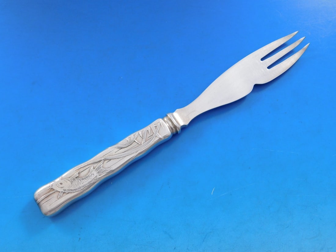 Tiffany Sterling Silver Melon Fork Knife Catfish 8 1/8 Lap Over Edge: Tiffany Sterling Silver Melon Fork Knife Catfish 8 1/8 Lap Over Edge This exquisite sterling silver melon fork/knife is crafted by Tiffany & Co. in the elegant Lap Over Edge pattern. Featuring a charm