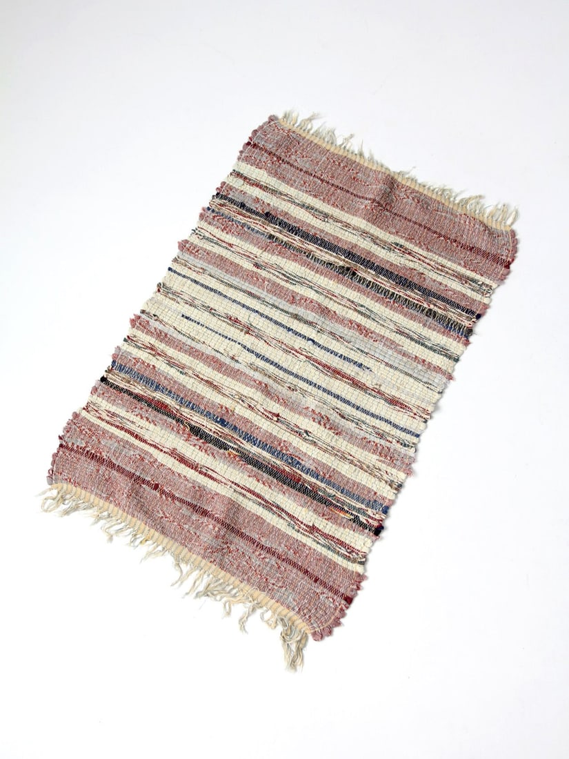 Handmade striped rag rug in red cream and blue 42.5 inch: Handmade striped rag rug in red cream and blue 42.5 inch This vintage American handmade rag rug features a soft, timeworn palette of red, cream, and blue, woven in a striped pattern. Its natural warmt