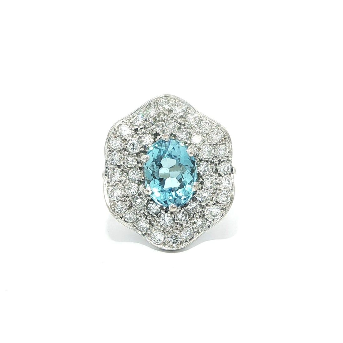 Oval Aquamarine and Diamond Cocktail Ring in Vintage White Gold Wavy Design: Oval Aquamarine and Diamond Cocktail Ring in Vintage White Gold Wavy Design This vintage cocktail ring features a deep blue oval brilliant cut natural aquamarine as the centerpiece, complemented by pa