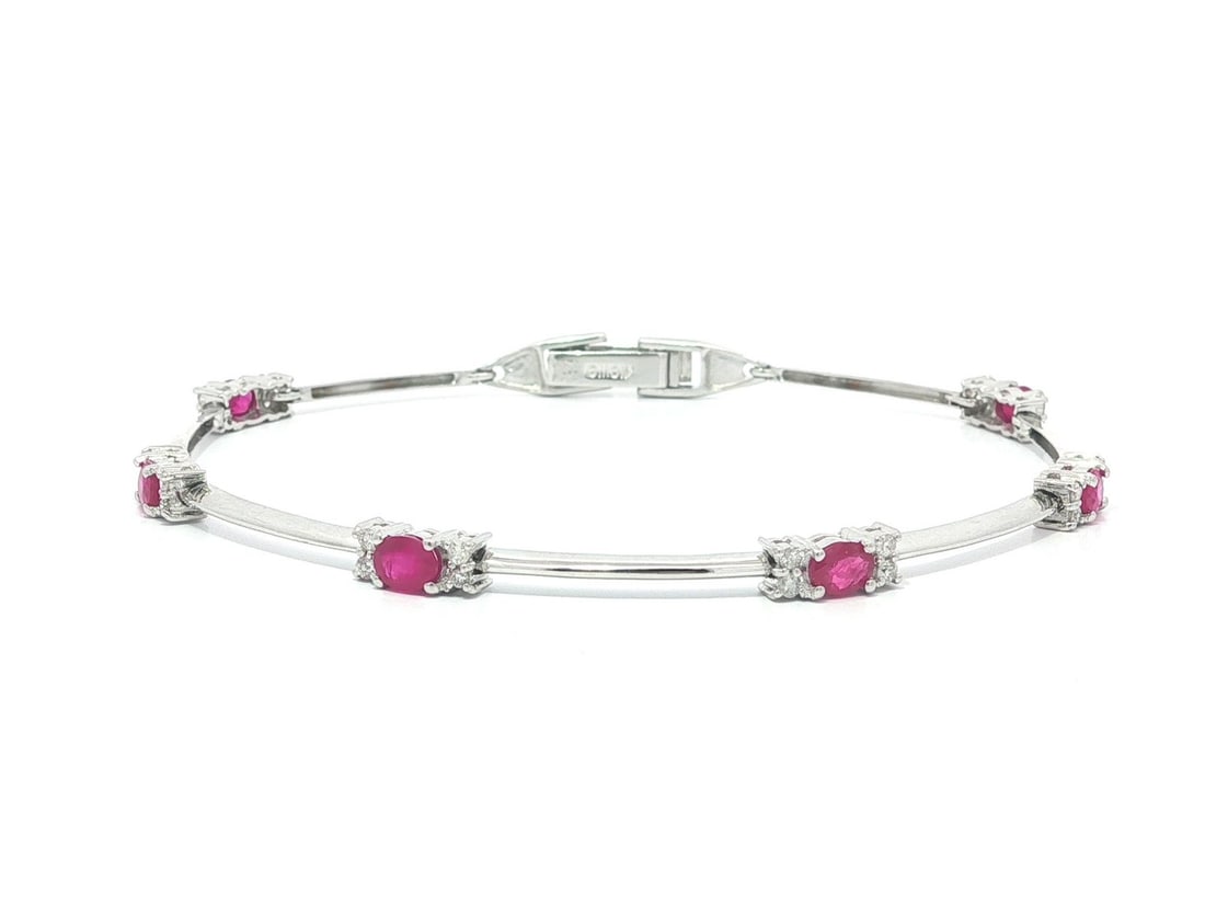 18k White Gold Bracelet with Natural Ruby and Diamond Cluster Stations: 18k White Gold Bracelet with Natural Ruby and Diamond Cluster Stations This elegant estate bracelet features six vivid red, natural oval-cut rubies and twenty-four round brilliant-cut natural diamonds