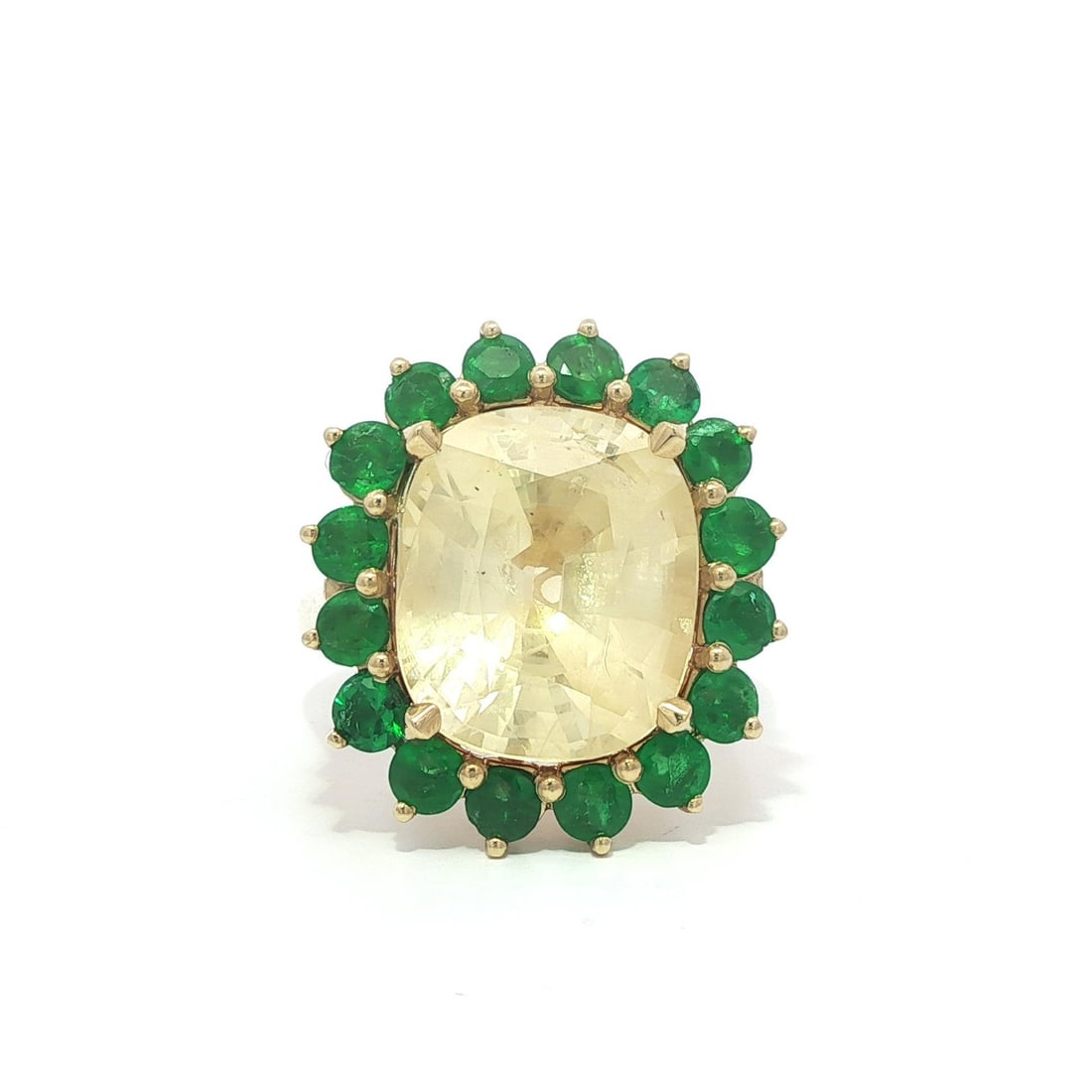 GIA Certified 18k Gold Ring With 12.41ct Pastel Yellow Sapphire And Emerald Halo: GIA Certified 18k Gold Ring With 12.41ct Pastel Yellow Sapphire And Emerald Halo This un-used cocktail ring showcases a natural, cushion-cut pastel yellow sapphire weighing 10.55 carats, set in solid 