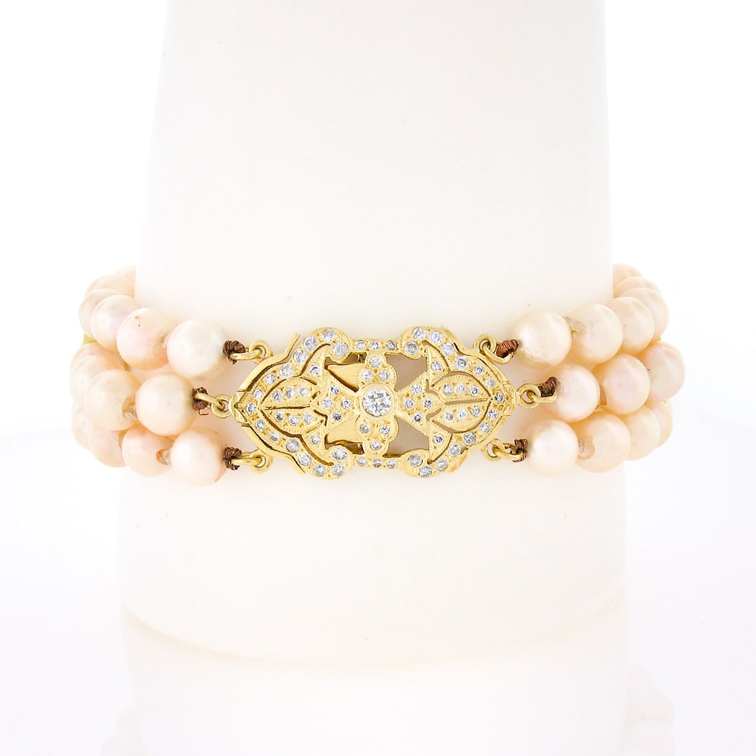 3 Row Cultured Pearl Bracelet in 14k Yellow Gold with 1.25ct Diamond Clasp: 3 Row Cultured Pearl Bracelet in 14k Yellow Gold with 1.25ct Diamond Clasp Statement bracelet featuring three rows of cultured pearls with yellow gold spacers and a diamond-covered clasp. Crafted in s