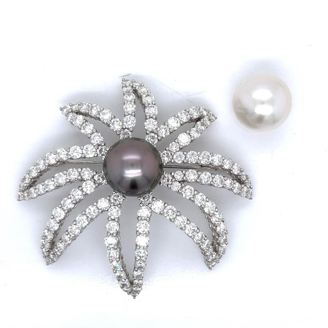 Platinum Brooch with 124 Diamonds and South Sea Pearls: Platinum Brooch with 124 Diamonds and South Sea Pearls This exquisite brooch features a stunning design incorporating a South Sea pearl and a multitude of sparkling diamonds. Weighing 33.8 grams, it i