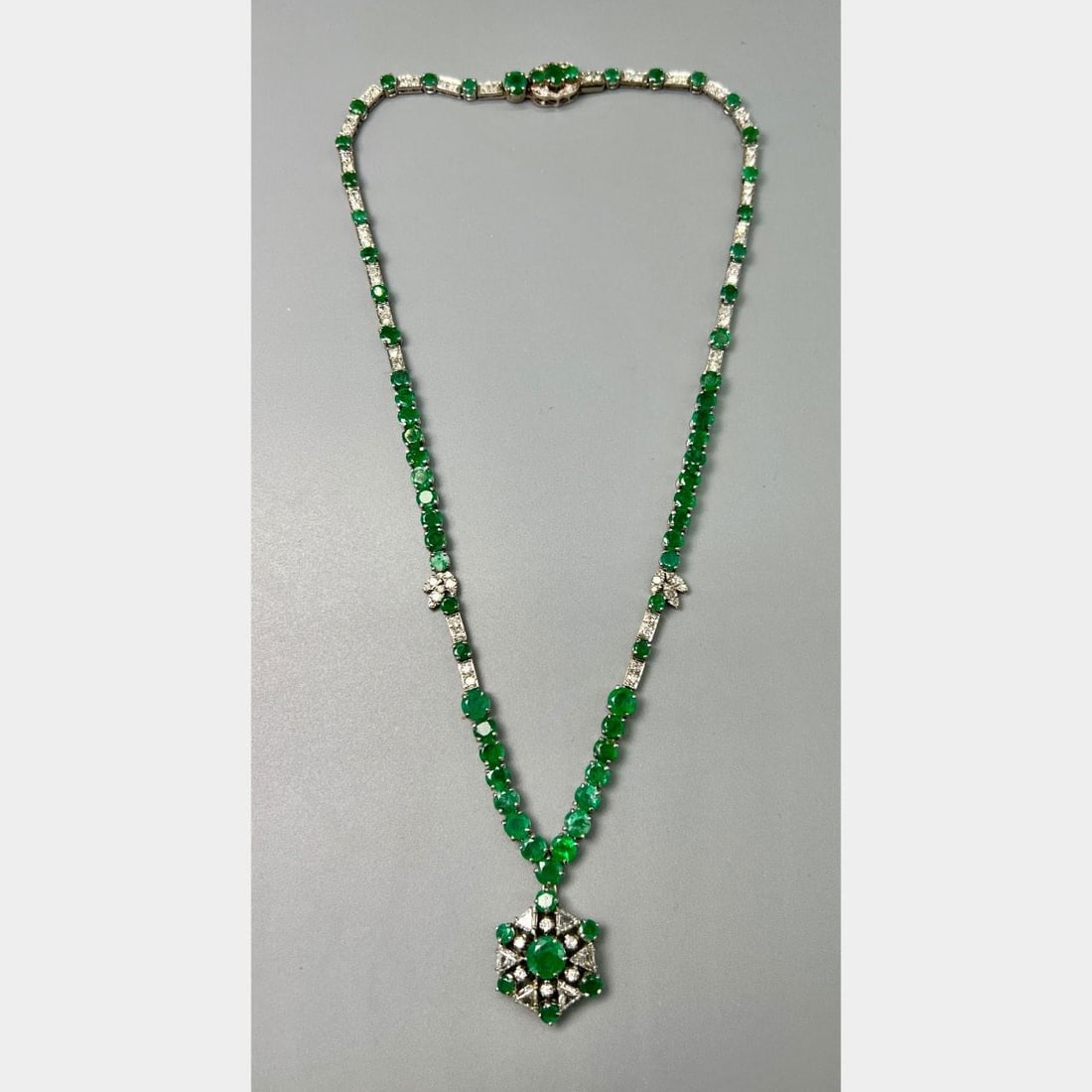 14K White Gold Necklace with Emeralds and Diamonds Circa 1950s: 14K White Gold Necklace with Emeralds and Diamonds Circa 1950s This 1950s necklace is crafted from 14K white gold and showcases approximately 20.00 carats of emeralds, some of which are cracked. The p