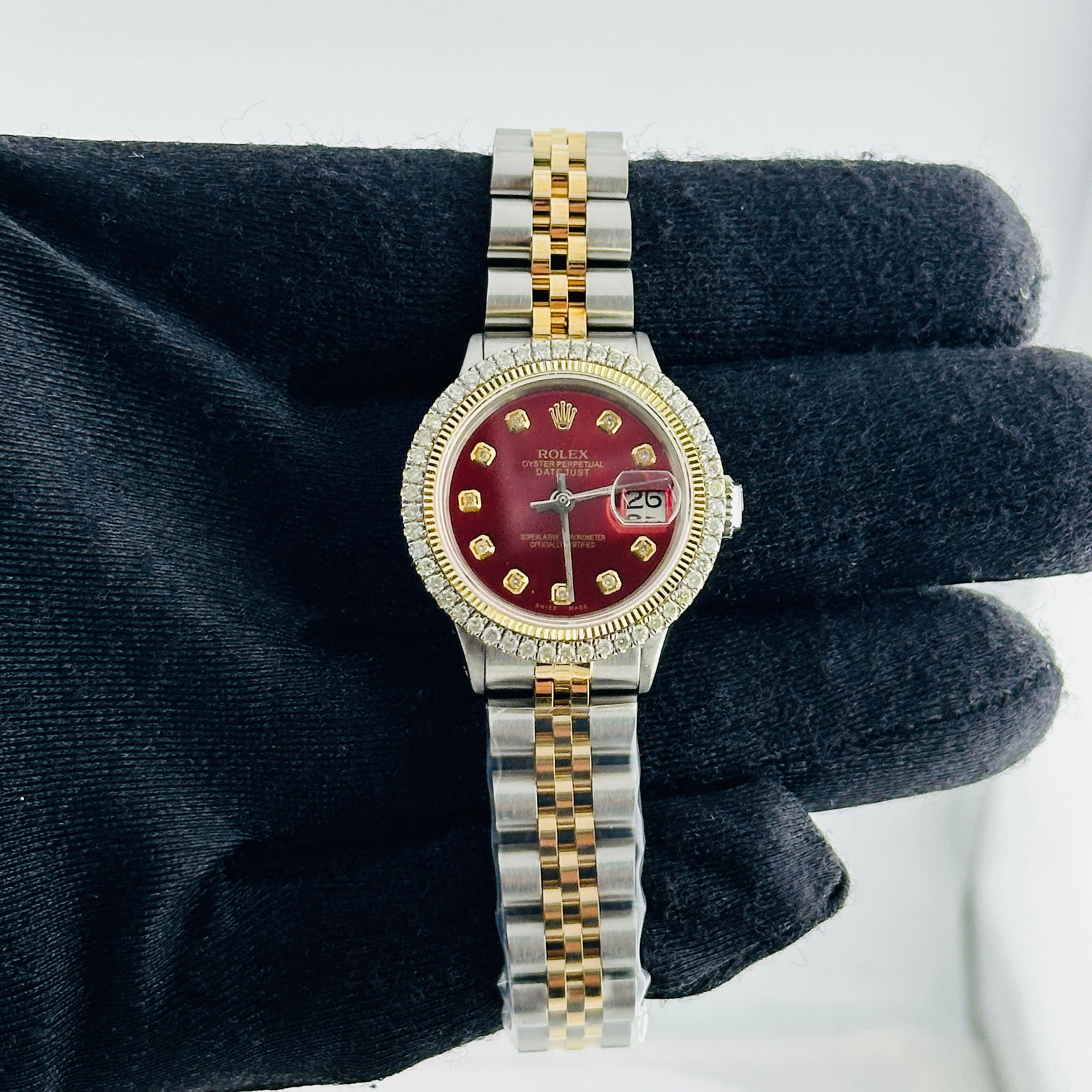 Ladies Rolex Datejust 6516 Aftermarket Jubilee Bracelet Diamond Marker Dial: Ladies Rolex Datejust 6516 Aftermarket Jubilee Bracelet Diamond Marker Dial This ladies' Rolex Datejust features an aftermarket red dial with yellow diamond markers, set within a prong yellow gold pla