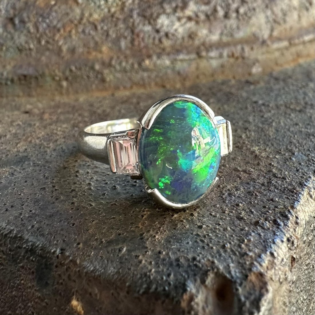 GIA Platinum Black Opal Diamond Cocktail Ring Size 6.5: GIA Platinum Black Opal Diamond Cocktail Ring Size 6.5 This platinum cocktail ring features a striking natural black opal, certified by GIA, weighing 2.34 carats in an oval double cabochon cut. The op