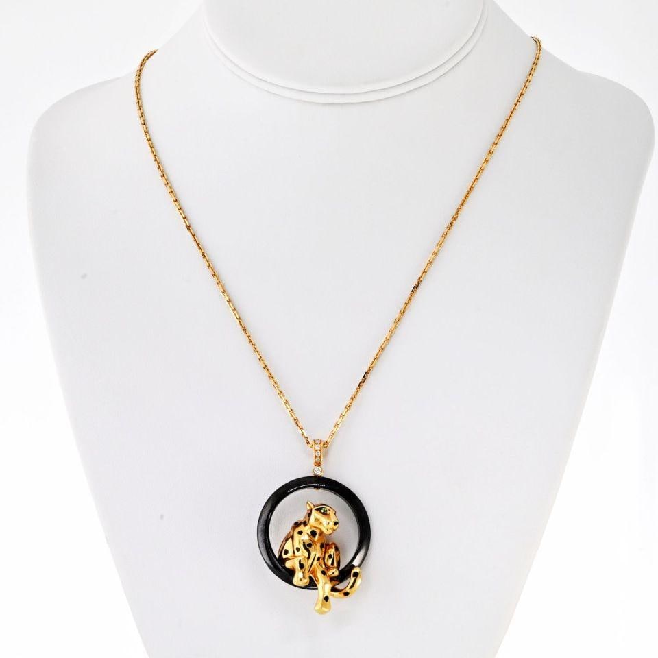 Cartier Panthere 18K Gold Pendant with Black Ceramic Ring: Cartier Panthere 18K Gold Pendant with Black Ceramic Ring Pre-owned Cartier pendant featuring a panther design perched on a ceramic ring with black lacquer spots. The design is accented by an onyx nos