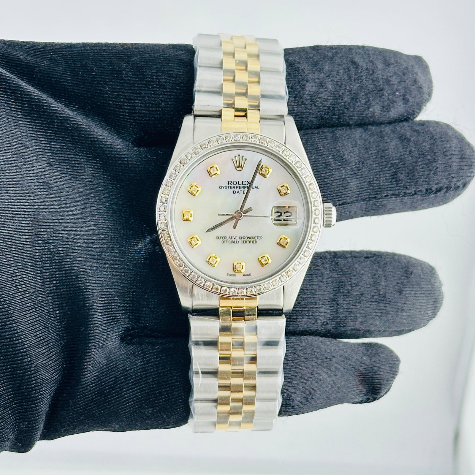 Rolex Date Ref 6694 Unisex Watch Aftermarket MOP Dial Jubilee Bracelet: Rolex Date Ref 6694 Unisex Watch Aftermarket MOP Dial Jubilee Bracelet Rolex Date watch, reference 6694, with an Aftermarket White MOP dial featuring yellow diamond markers. It is presented on an Afte