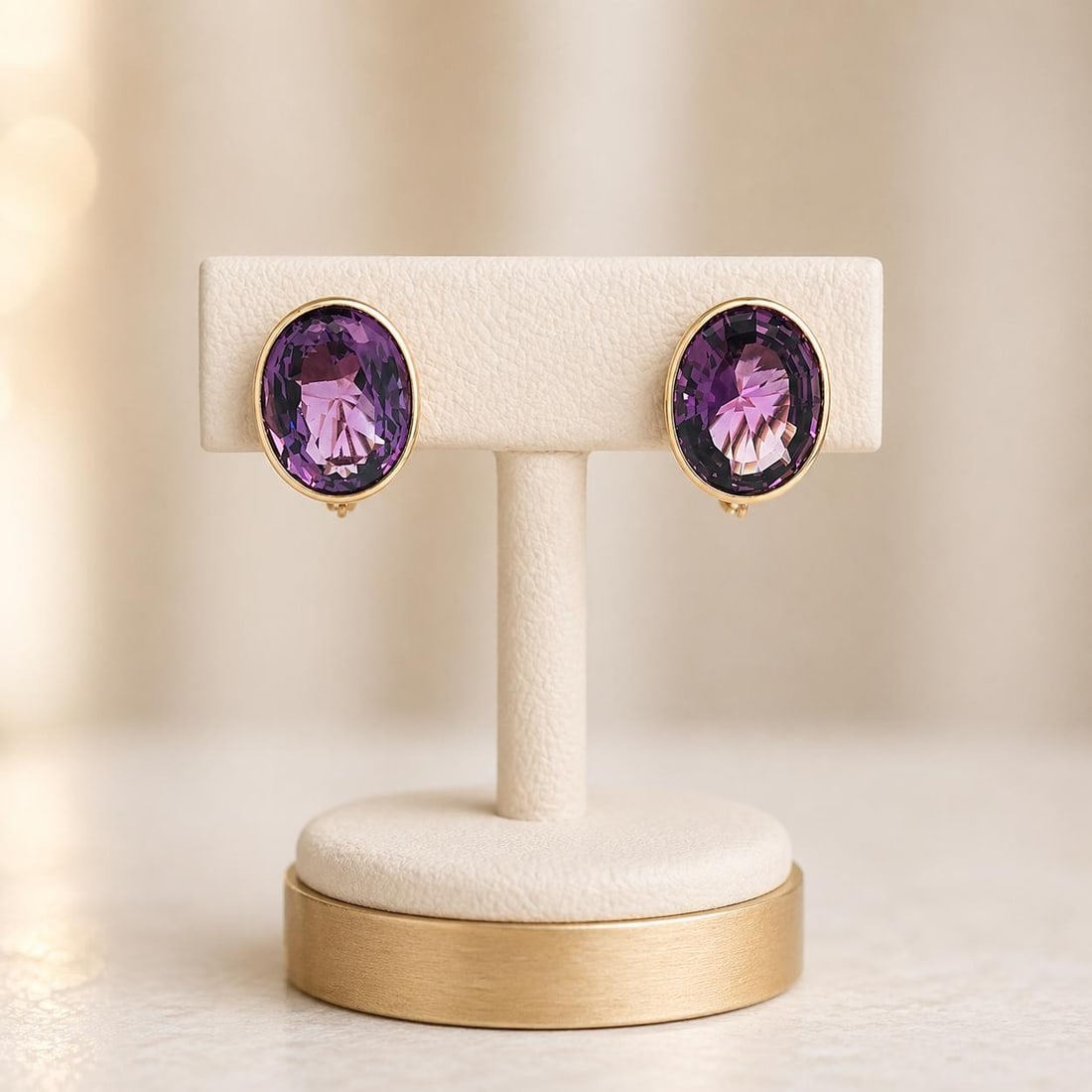 14k Gold Amethyst Oval Bezel Omega Earrings 30ctw: 14k Gold Amethyst Oval Bezel Omega Earrings 30ctw These elegant earrings feature two large natural oval step-cut amethysts with a combined weight of approximately 30 carats. The amethysts display a ri