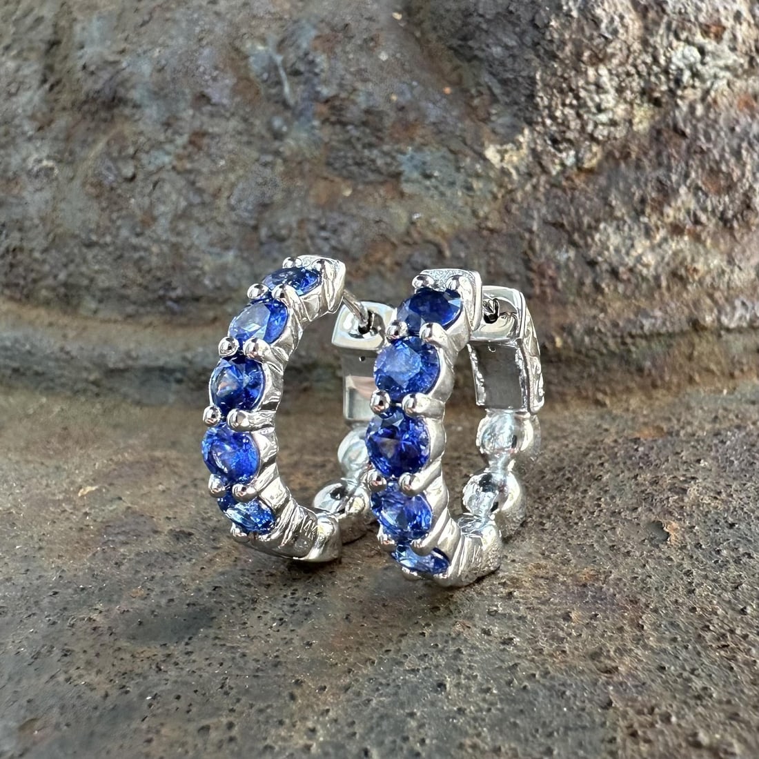 14k White Gold Sapphire Hoop Earrings 2.2ctw 10 Stones: 14k White Gold Sapphire Hoop Earrings 2.2ctw 10 Stones These classic hoop earrings are crafted from solid 14k white gold and feature ten natural round brilliant cut sapphires in a vibrant blue hue. Th