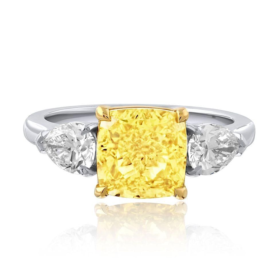 GIA 3.01ct Fancy Vivid Yellow Cushion Diamond Three Stone Ring: GIA 3.01ct Fancy Vivid Yellow Cushion Diamond Three Stone Ring Three-stone engagement ring featuring a 3.01 ct cushion cut diamond with VVS2 clarity. Designed in platinum and 18K yellow gold, this rin