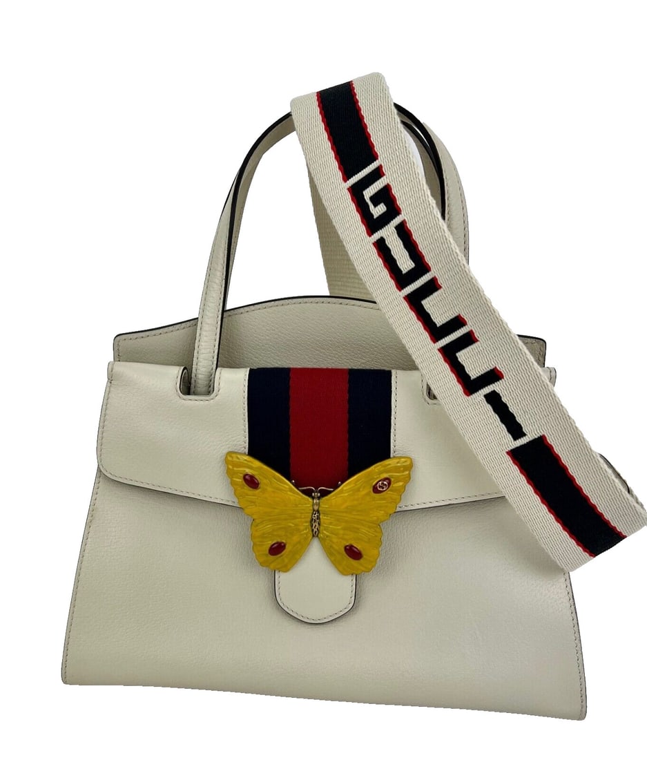 Gucci Linea Medium Butterfly Top Handle Bag Ivory Leather Antique Gold: Gucci Linea Medium Butterfly Top Handle Bag Ivory Leather Antique Gold Introducing the Gucci Linea Medium Totem Web Stripped Yellow Butterfly Top Handle Bag, an exquisite blend of elegance and functio