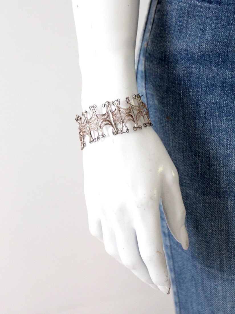 Exquisite Vintage Silver Tone Filigree Cuff Bracelet: Exquisite Vintage Silver Tone Filigree Cuff Bracelet Discover this exquisite vintage filigree cuff bracelet, featuring a stunning silver tone finish and a captivating geometric design. The bracelet is