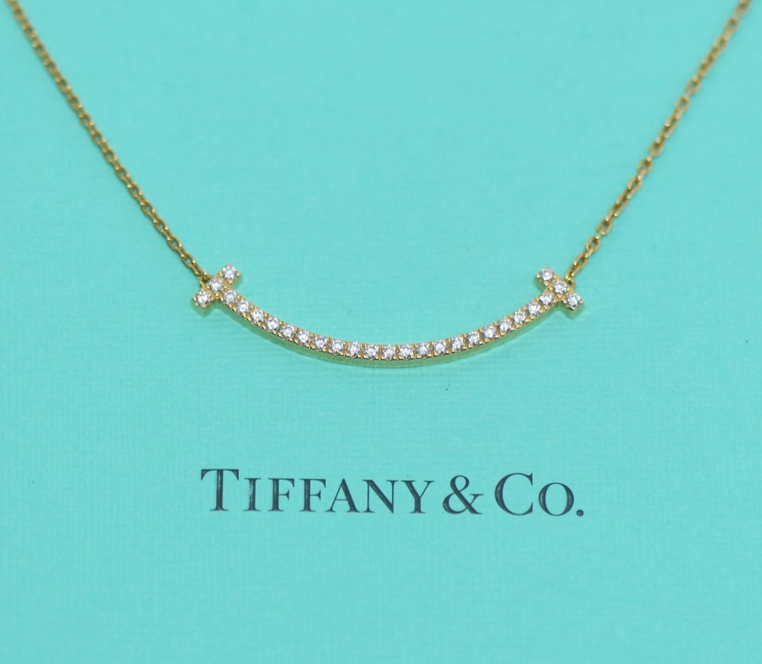 Tiffany & Co T Smile 18K Yellow Gold Diamond Pendant Necklace: Tiffany & Co T Smile 18K Yellow Gold Diamond Pendant Necklace Elevate your jewelry collection with the Tiffany & Co. T Smile Diamond Necklace. This stunning pendant is crafted from luxurious 18K yello
